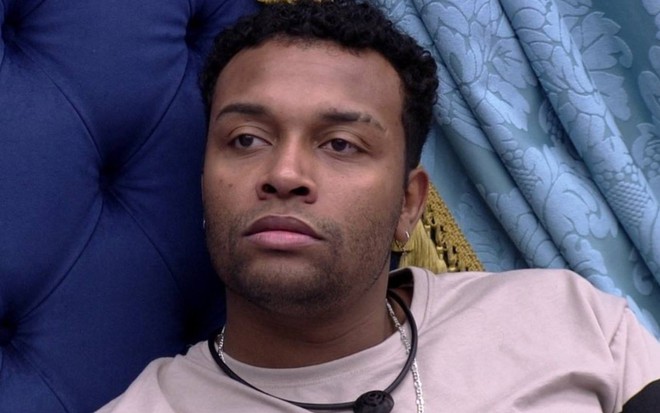 Foto de Nego Di no BBB 20; ele veste camiseta branca e usa microfone no pescoço