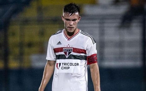 Felipe Negrucci, do São Paulo, em campo com uniforme branco com listras vermelha e preta