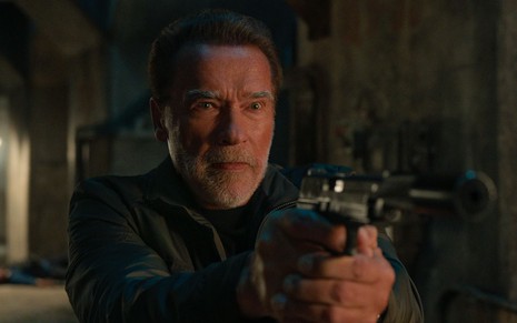 Arnold Schwarzenegger segurando uma arma