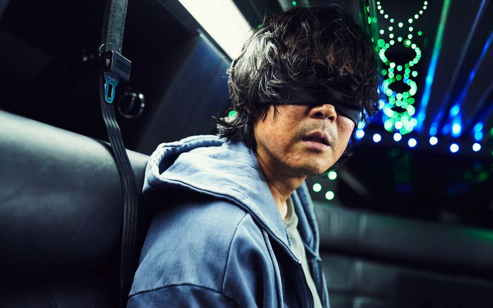 Lee Jung-jae está vendado dentro de um carro em cena de Round 6, da Netflix