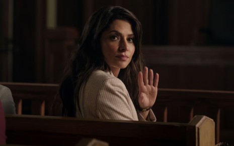 Sarah Shahi olha para a câmera e dá tchauzinho com a mão em cena da série Sex/Life