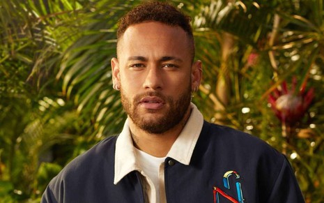 Neymar posando com cara séria em meio a plantas