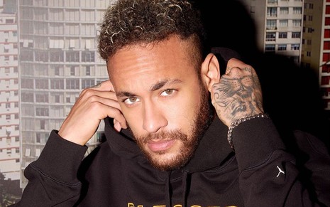 Neymar Jr. começa a colocar o capuz do moletom na cabeça e mostra expressão séria em foto do Instagram