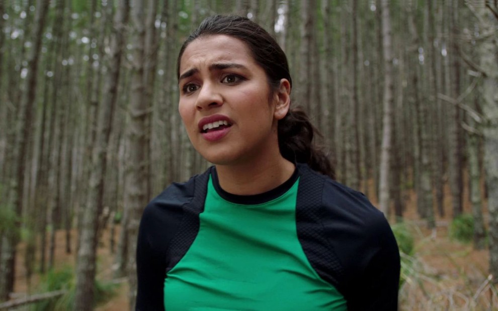 Com camiseta esportiva verde e preta, Tessa Rao tem expressão de tensão em cena de Power Rangers Dino Fury