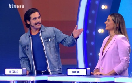 De jaqueta jeans, Nicholas Prattes aponta para Bruna, sua namorada, no palco do Caldeirão