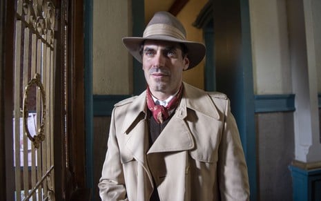 O ator Nikolas Antunes em cena de Além da Ilusãocom o figurino do personagem Plínio, que conta com chapéu