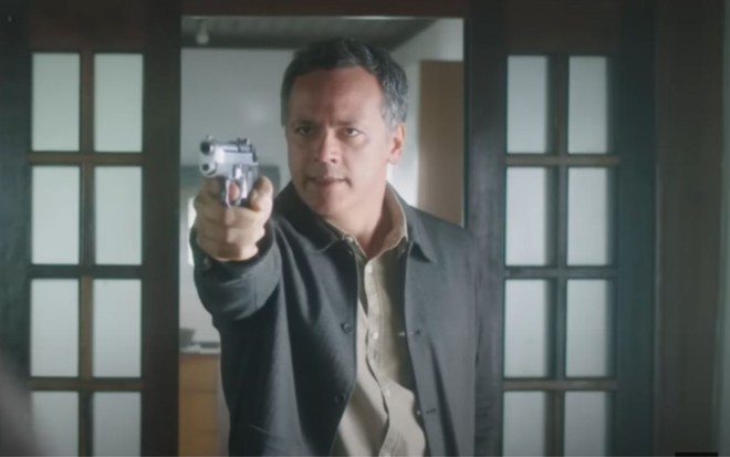 Danton Mello aponta arma em cena do filme Ninguém É de Ninguém