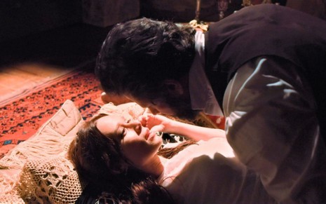 Luísa (Mariana Ximenes) e dom Pedro 2º (Selton Mello) estão deitados em chão de teatro em cena de Nos Tempos do Imperador