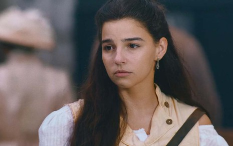A atriz Gabriel Medvedovski olha para o lado com cara de tristeza em cena de Nos Tempos do Imperador, novela das seis da Globo