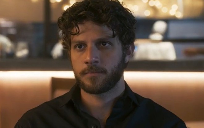 Em cena de Travessia, Chay Suede está com a expressão enigmática