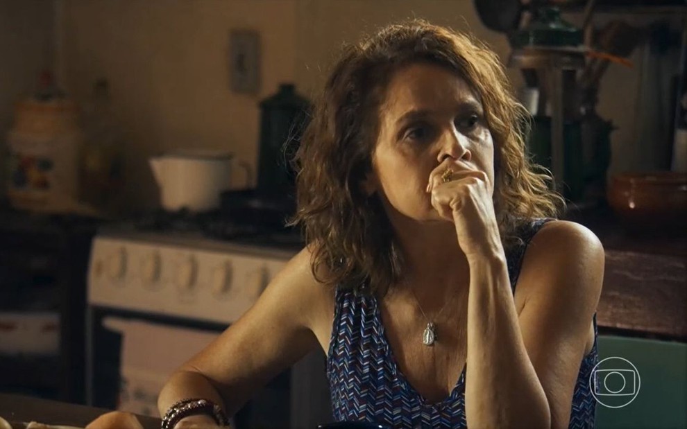 Em cena de Travessia, Drica Moraes está com a mão na altura da boca, pensativa