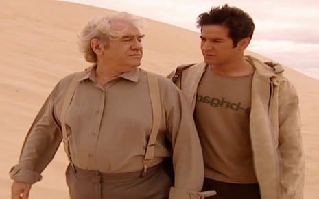 Juca de Oliveira e Murilo Benício em cena de O Clone: atores estão no meio do deserto e caminham juntos