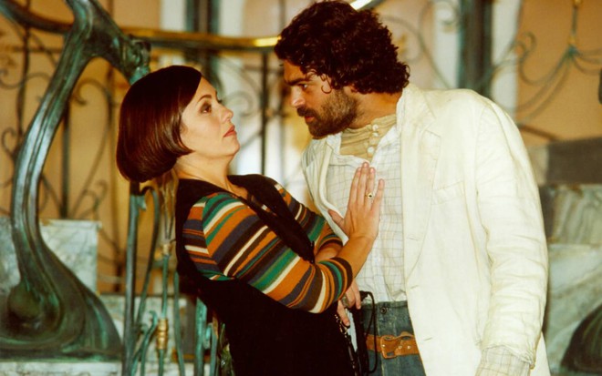 Catarina (Adriana Esteves) e Petruchio (Eduardo Moscovis) em cena de O Cravo e a Rosa (2000), ele tenta abraçá-la, ela faz cara de novo e tenta afastá-lo