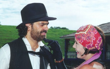 Edu Moscovis e Adriana Esteves se olham em cena de Cravo e a Rosa, novela da Globo