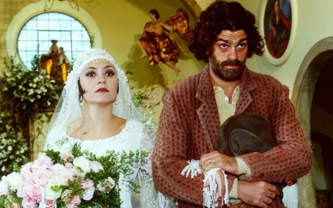 Adriana Esteves e Edu Moscovis em cena de Cravo e a Rosa: casal de atores está vestido de noivos