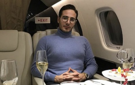 Shimon Hayut sentado dentro de um avião em cena do documentário O Golpista do Tinder