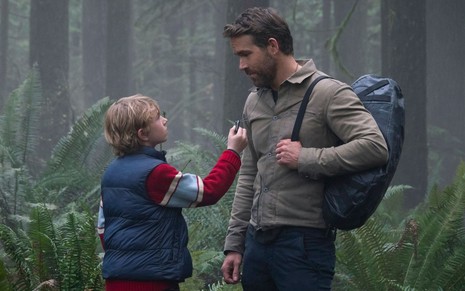 Walker Scobell e Ryan Reynolds conversam na floresta em cena do filme O Projeto Adam