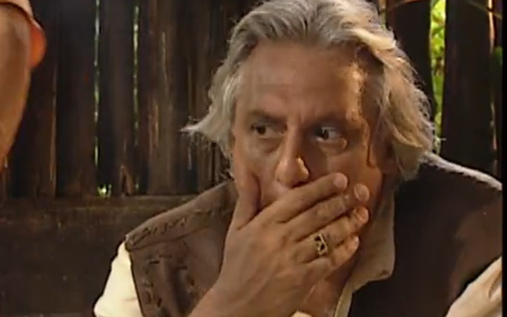 O ator Antonio Fagundes com expressão séria, com a mão na boca, em cena de O Rei do Gado