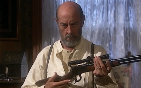 O ator Raul Cortez segurando arma em cena de O Rei do Gado