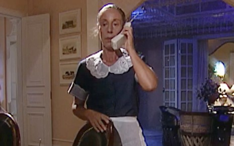 A atriz Maria Helena Pader falando ao telefone em cena de O Rei do Gado