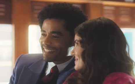 Os atores Diogo Almeida e Camila Queiroz lado a lado em banco de trem em cena de Amor Perfeito
