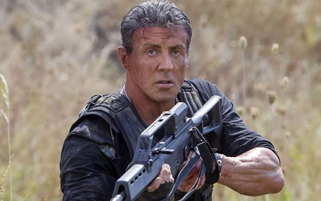 Sylvester Stallone carrega arma em cena do filme Os Mercenários 3