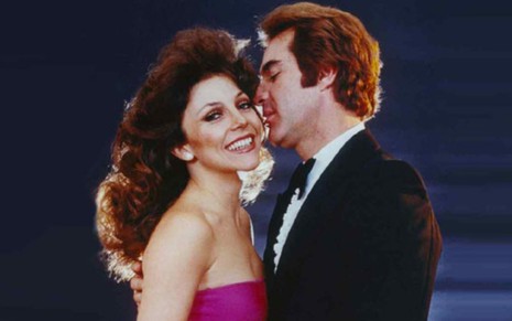 Os protagonistas de Os Ricos Também Choram; homem próximo ao rosto de mulher, ela sorri, ambos com trajes de gala, em foto de 1979