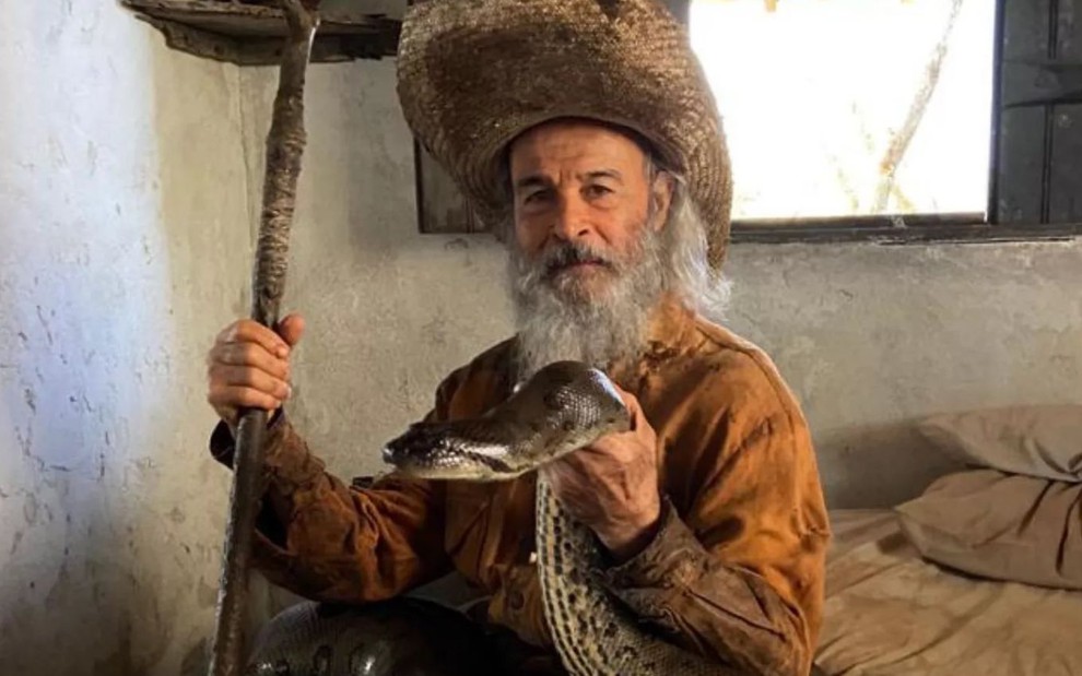 Osmar Prado, como seu personagem em Pantanal, está segurando uma cobra