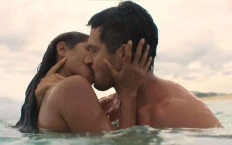 Em cena de Travessia, Romulo Estrela e Lucy Alves estão se beijando dentro do mar