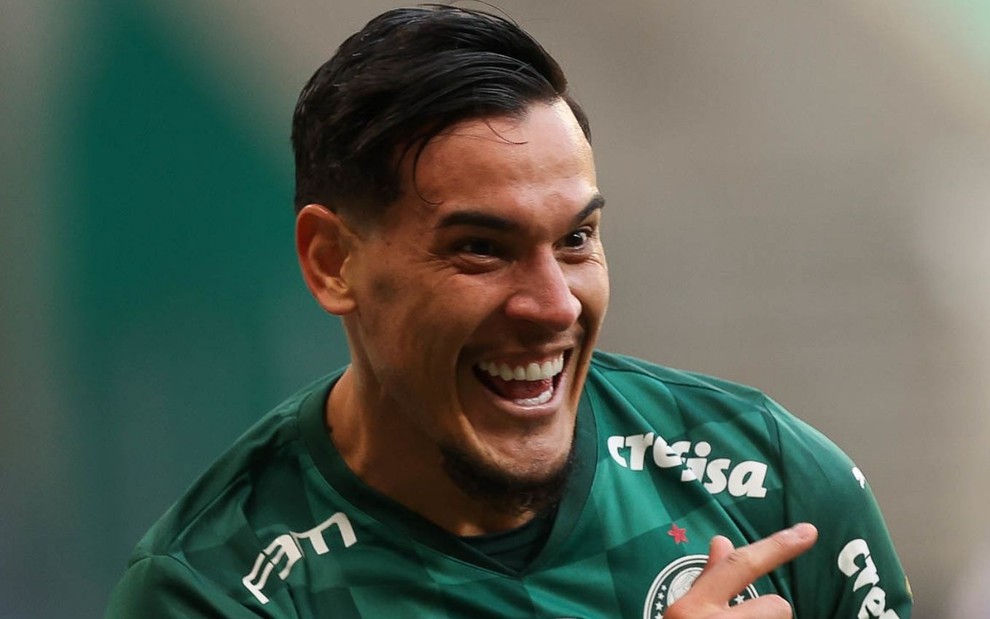 Gustavo Gómez sorri ao comemorar gol pelo Palmeiras; ele está com o uniforme tradicional verde
