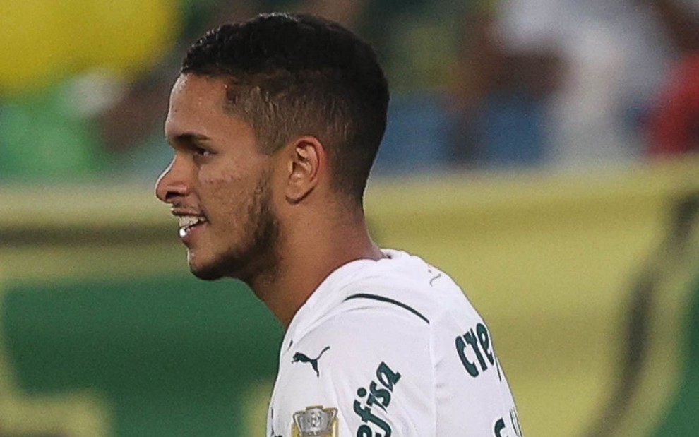 Jogador Gabriel Silva, do Palmeiras, vestindo uniforme branco com detalhes verde e comemorando gol