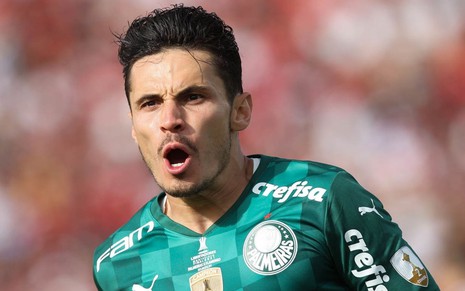 Jogador Raphael Veiga, do Palmeiras, comemora gol feito e veste uniforme verde com detalhes brancos