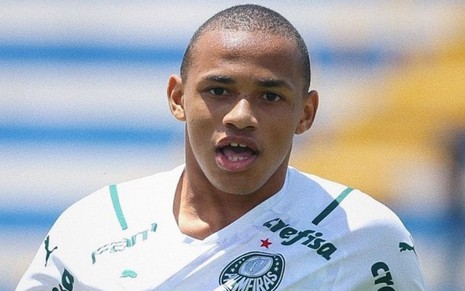 Jogador Jhonatan, do Palmeiras, comemora gol em partida e veste uniforme branco com detalhes verdes