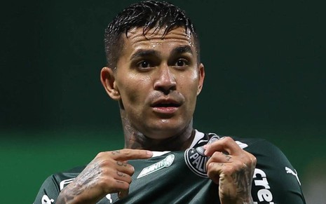 Dudu, do Palmeiras, comemora gol e aponta para escudo do uniforme verde com detalhes brancos