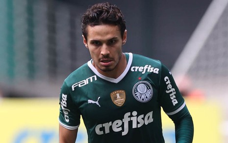 Raphael Veiga, do Palmeiras, veste uniforme com camisa verde e calção branco durante partida