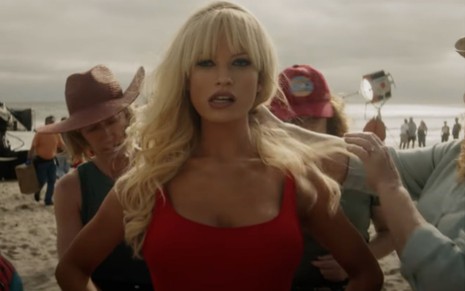 Lily James de maiô vermelho em cena do trailer da minissérie Pam & Tommy