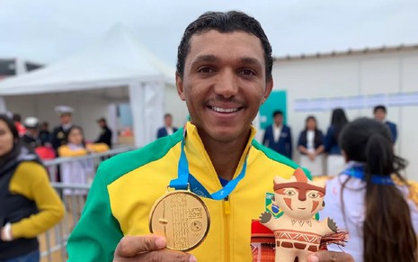Izaquias Queiroz no Pan de 2019 com um casaco verde amarelo e medalhas