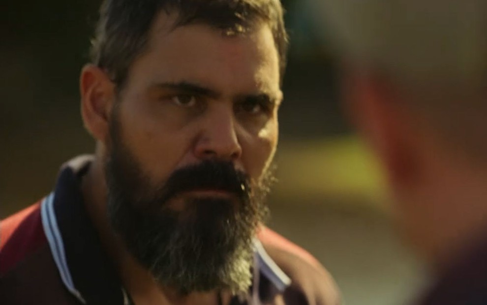 O ator Juliano Cazarré como Alcides em Pantanal; ele está olhando para frente com cara de apreensivo