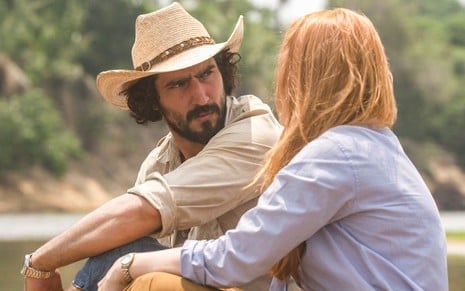 O ator Renato Góes contracena com Malu Rodrigues à beira de um rio na novela Pantanal