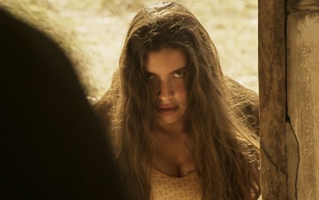 A atriz Alanis Guillen como Juma em Pantanal; ela está olhando para o lado com a boca levemente aberta e cara de desconfiada