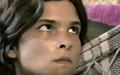 A atriz Cristiana Oliveira como Juma em Pantanal; ela está em uma rede, olhando para cima com cara de assustada