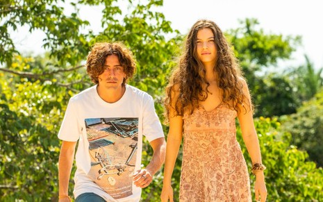Os atores Jesuita Barbosa e Alanis Guillen, caracterizados como seus personagens em Pantanal, estão posando para a foto na beira de um rio
