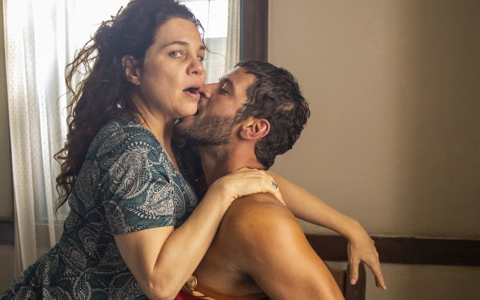A atriz Isabel Teixeira tem o queixo mordido por Leandro Lima, ambos estão caracterizados como seus personagens em Pantanal