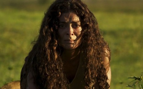 Maria (Juliana Paes) encara uma onça em cena emque está com cabelos soltos e agachada em um campo verde