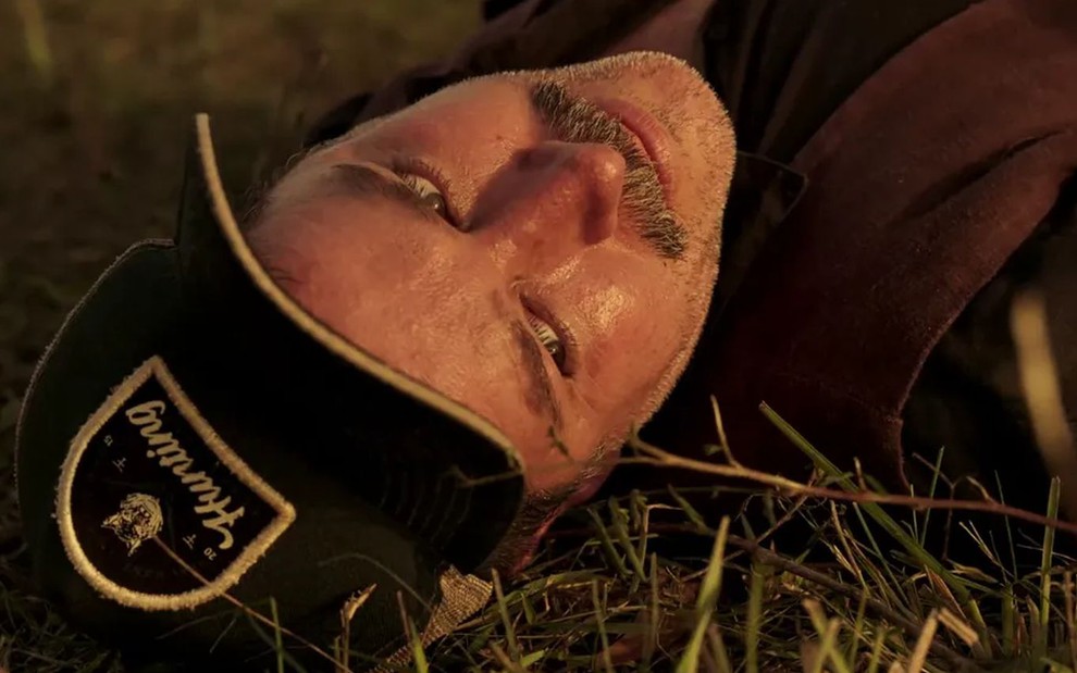 O ator Murilo Benício como Tenório em Pantanal; ele está deitado na grama após ser atacado, olhando para cima com cara de dor