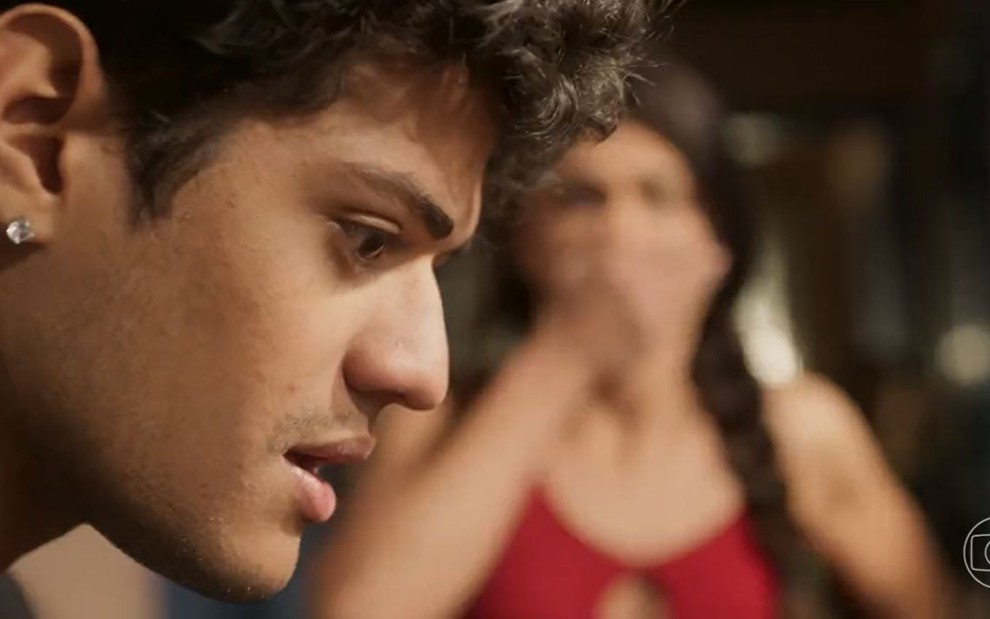 O ator Gabriel Santana e a atriz Paula Barbosa como Renato e Zefa em Pantanal; ele está de lado, olhando para baixo com cara de impressionado equanto ela surge em segundo plano olhando assustada, com a mão na boca