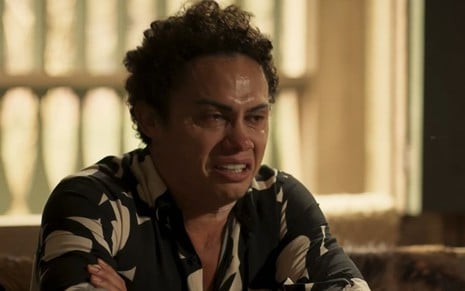 O ator Silvero Pereira como Zaquieu em Pantanal; ele está sentado de lado, olhando para frente e chorando, com lágrimas no rosto