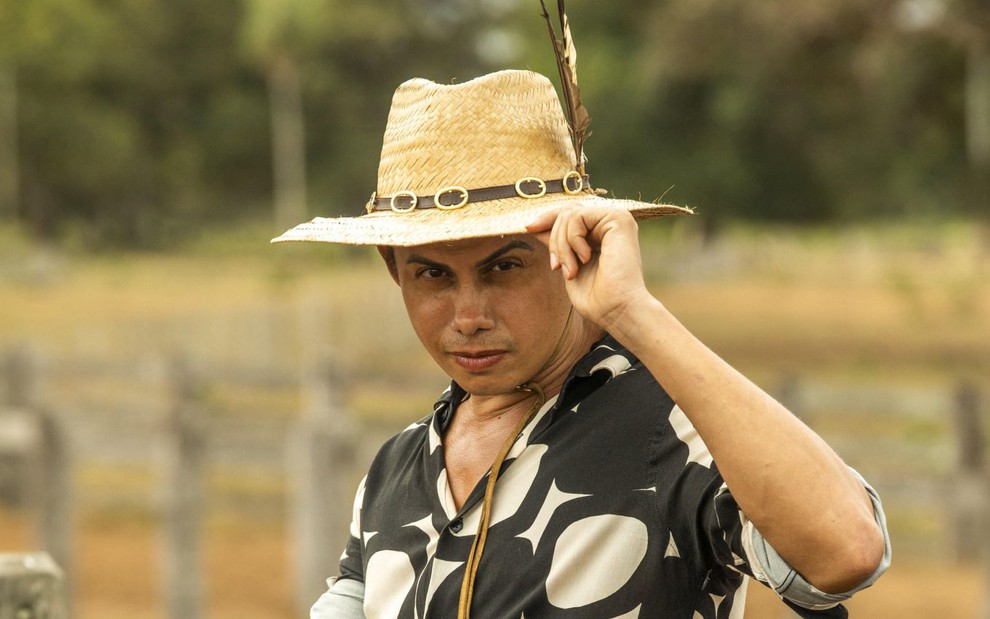 O ator Silvero Pereira como Zaquieu em Pantanal; ele está de chapéu olhando para frente com cara provocante e com a mão na aba do chapéu
