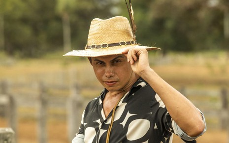 O ator Silvero Pereira como Zaquieu em Pantanal; ele está de chapéu olhando para frente com cara provocante e com a mão na aba do chapéu
