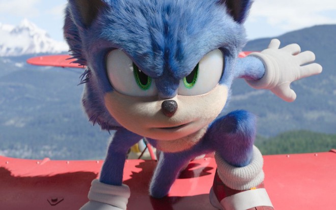 Pôster de Sonic 2: O Filme; personagem está em cima de um avião vermelho com o rosto próximo a câmera